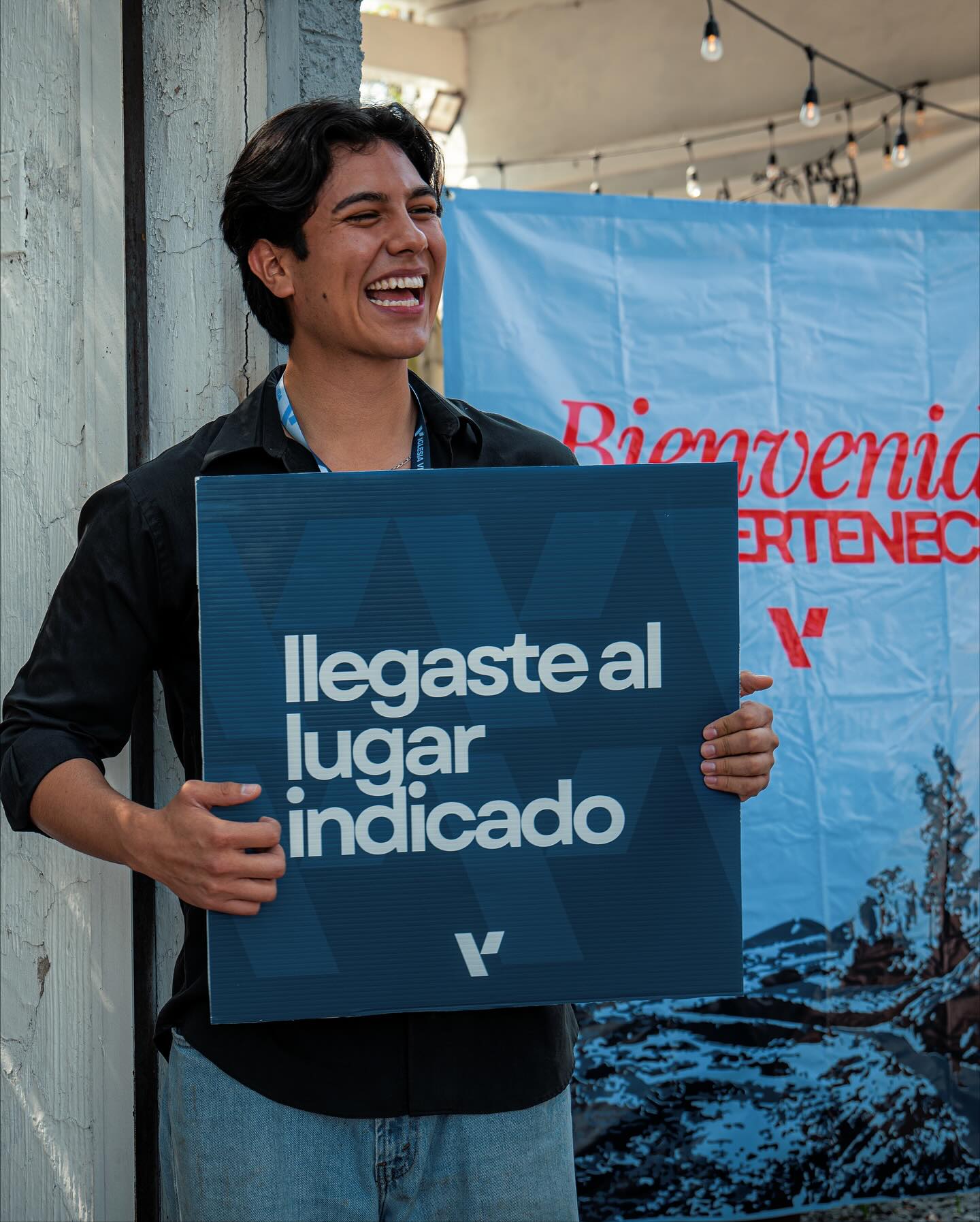 Joven con letrero de 'Llegaste al lugar indicado'
